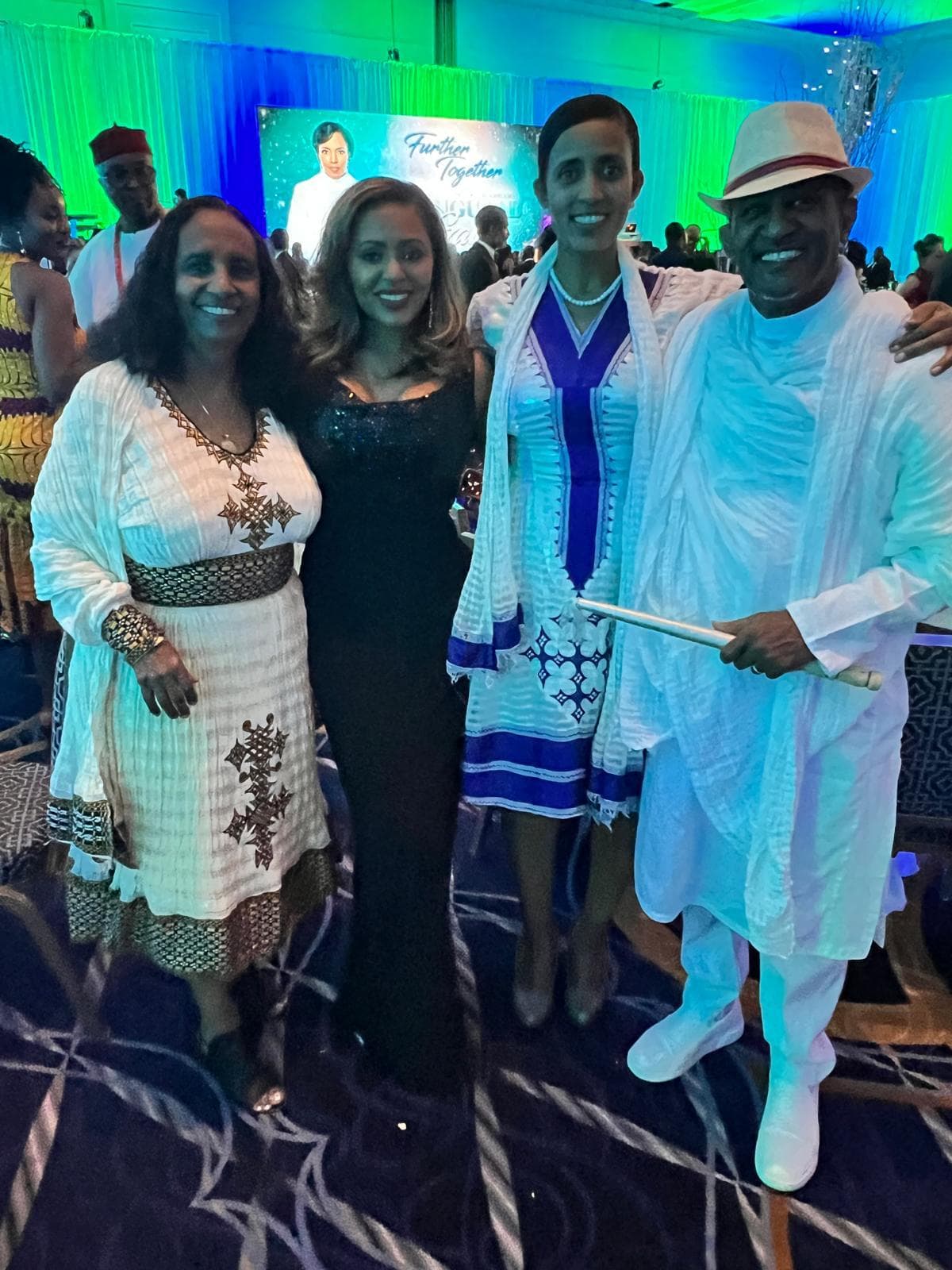Community members in traditional dress at an evening event